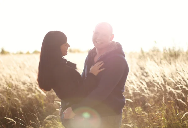 Joyeux jeune couple dans un champ — Photo