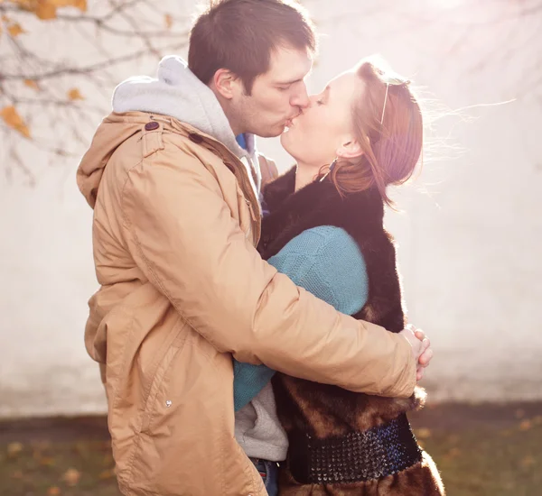 Young couple kisses in the autumn park — Stock Photo, Image