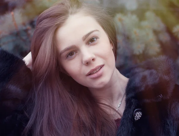 Girl straightens hair in winter park — Stock Photo, Image