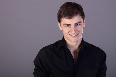 siyah bir gömlek gülümseyen genç adam