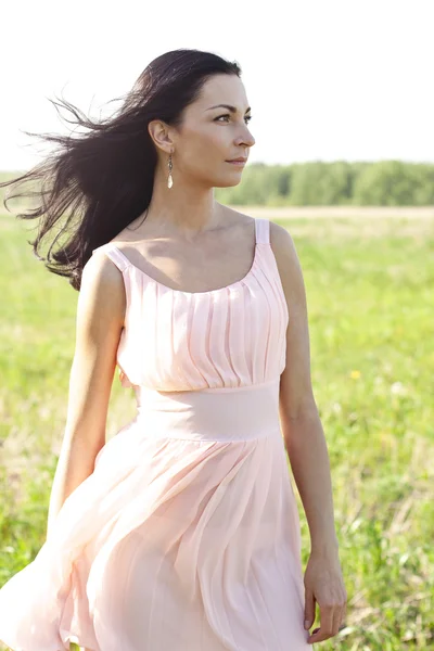 Woman in pink dress  in a field — Stock Photo, Image