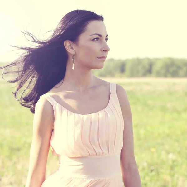 Woman in pink dress  in a field — Stock Photo, Image