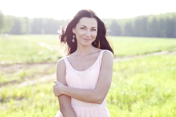 Woman in pink dress in a field — Stock Photo, Image