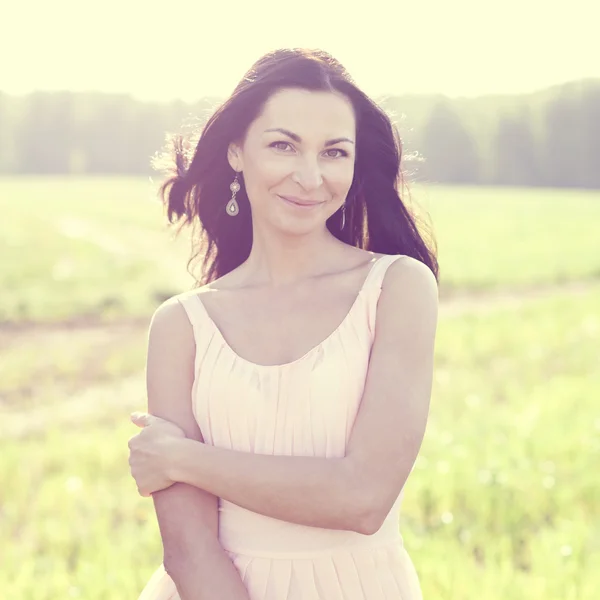 Woman in pink dress in a field — Stock Photo, Image