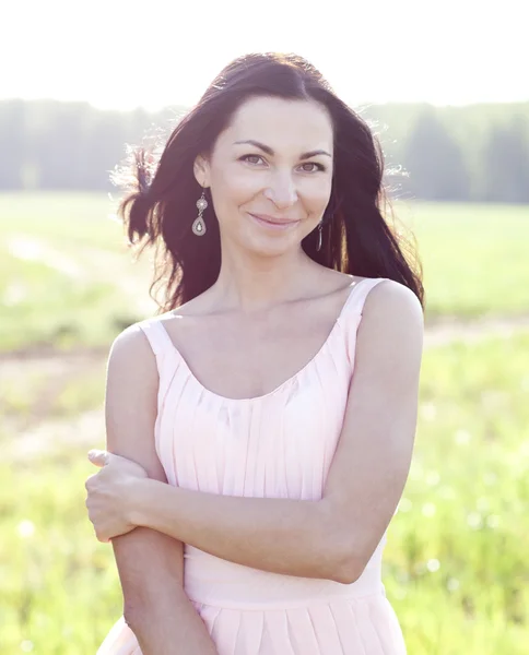 Woman in pink dress in a field — Stock Photo, Image