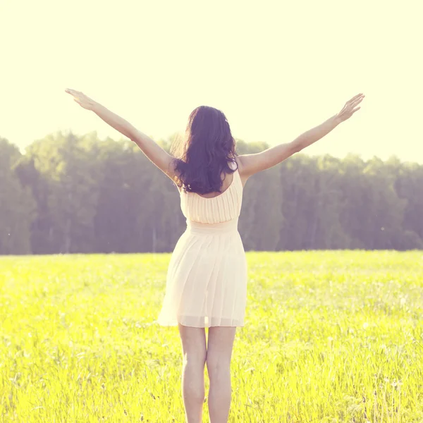Chica en un vestido saltando en un campo — Foto de Stock