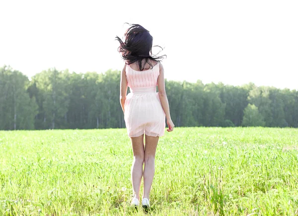 Chica en un vestido saltando en un campo —  Fotos de Stock
