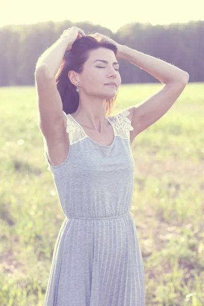 Woman in a dress standing in a field — Stock Photo, Image