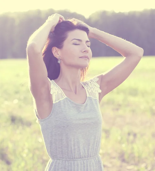 Woman in a dress standing in a field — Stock Photo, Image