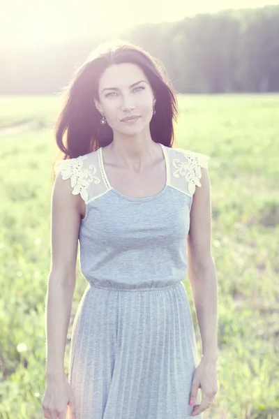 Woman in a dress standing in a field — Stock Photo, Image