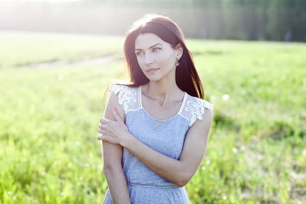 Žena v šatech, stojící v poli — Stock fotografie