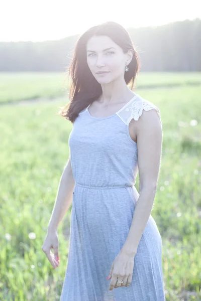 Woman in a dress standing in a field — Stock Photo, Image