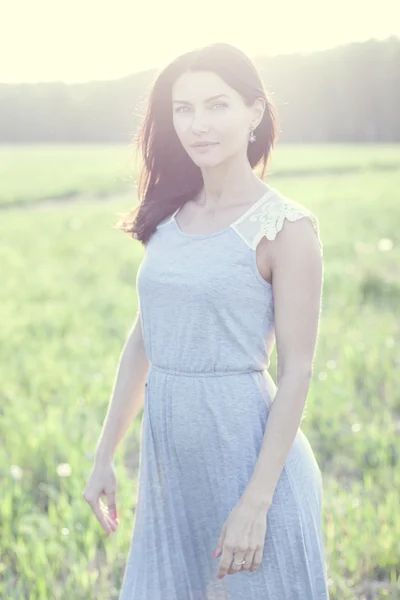 Woman in a dress standing in a field — Stock Photo, Image