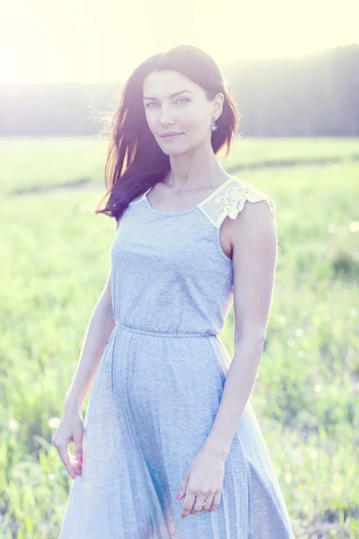 Woman in a dress standing in a field — Stock Photo, Image