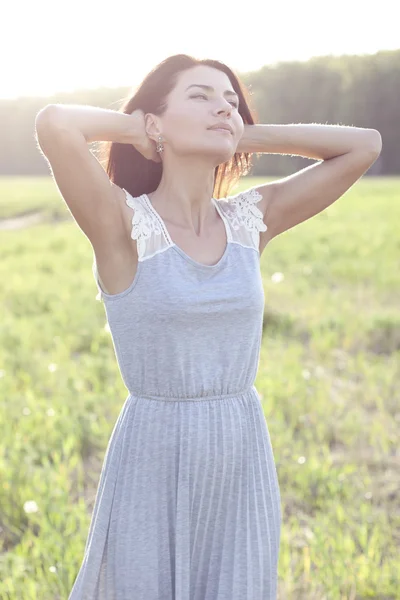 Girl in a dress standing in a field — Stock Photo, Image