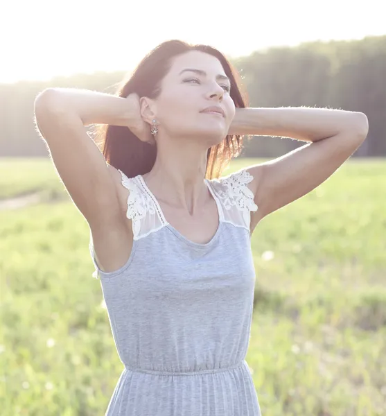 Girl in a dress standing in a field — Stock Photo, Image