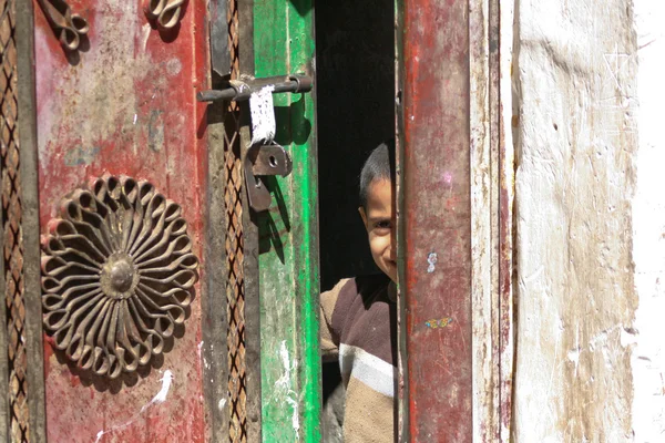 Niño en la puerta en el casco antiguo de Sanaa (Yemen ). — Foto de Stock