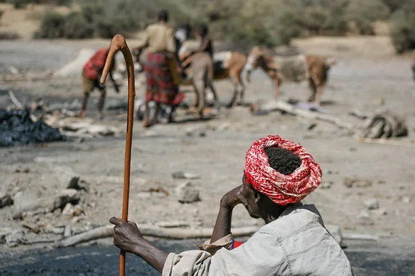 Elder man observes workers to the salt mine in the former volcan — Stock Photo, Image