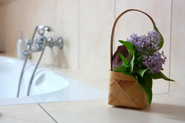 Cesta con toalla y flores en el baño —  Fotos de Stock