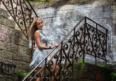 Genç, mutlu bir kız güneşli bir günde sokakta yürüyor..