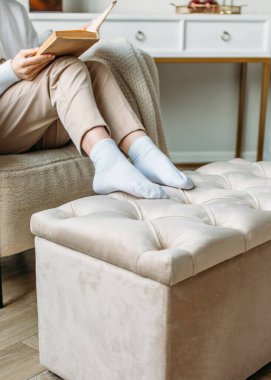 İçerde, parlak bir odada, döşenmiş mobilyalar, doğal ışık, sakin renkler.