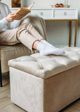 İçerde, parlak bir odada, döşenmiş mobilyalar, doğal ışık, sakin renkler.