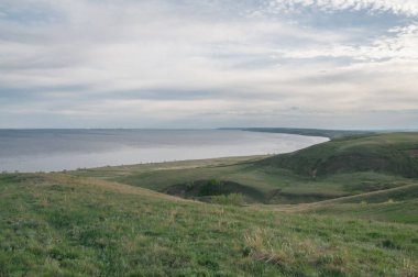 Rusya 'nın Saratov bölgesindeki yeşil tepelerden güzel Volga nehrine bakıyorum.