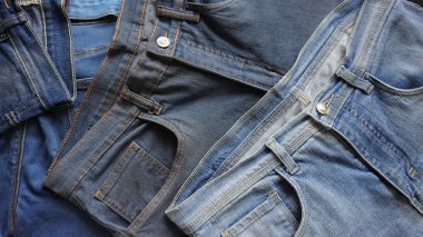 Çeşitli mavi tonlar ve boyutlarda kot pantolon yığını