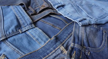 Çeşitli mavi tonlar ve boyutlarda kot pantolon yığını