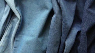 Close-Up Pan Shot Of Crumpled Denim Fabric showing different shades from Light Blue to Dark Blue
