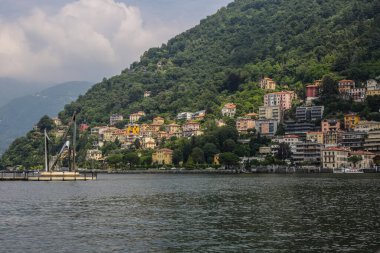Como, İtalya - 15 Haziran 2017: Como Gölü 'ndeki Yaşam Elektrik Anıtı ve Arkaplanda Renkli Geleneksel Binalar