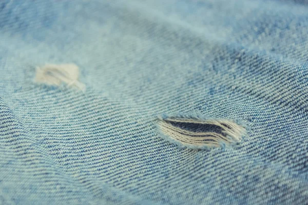 Fabric ripped hole classic denim jeans close up texture — Stock Photo, Image