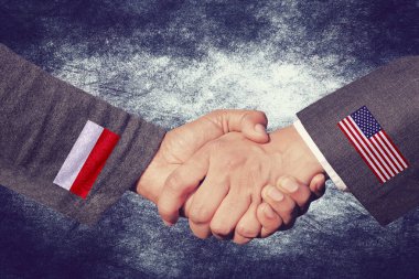 İşbirliği sembolü olarak Polonya ve ABD arasında bir tokalaşma