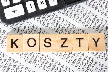 Ahşap küplere, mali belgeye ve arka plan için hesap makinesine yazılmış koszty sözcüğü