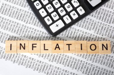 Arkaplan için enflasyon kelimesi ahşap küplere, mali belgeye ve hesap makinesine yazıldı