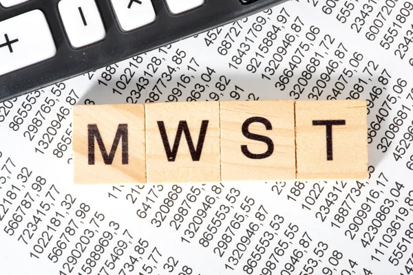 Arkaplan için ahşap küplere, mali belgeye ve hesap makinesine yazılmış mwst kelimesi