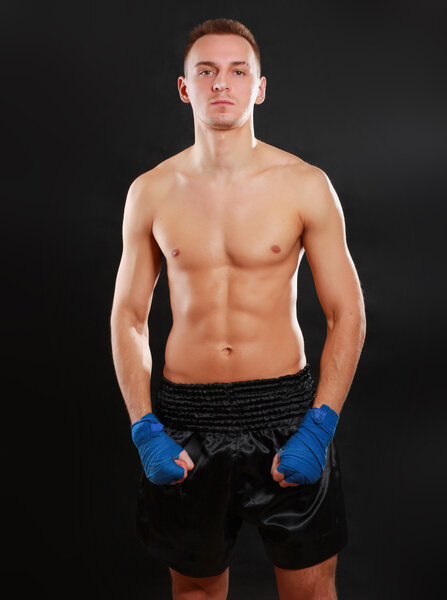 Молодой красивый боксер изолирован на черном фоне
