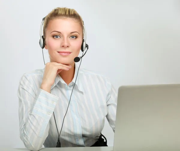 Portret pięknej bizneswoman pracującej przy biurku ze słuchawkami i laptopem — Zdjęcie stockowe