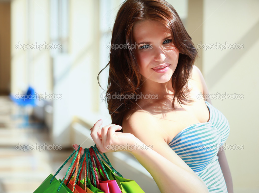 Smiling girl with shopping bags in shop