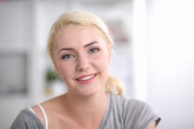 Genç güleryüzlü güzel kadın kanepede onun odasında oturuyordu