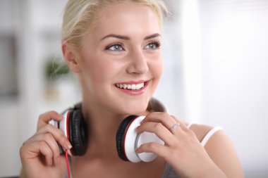 Evdeki genç ve güzel kadın kanepede oturup müzik dinliyor.