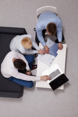 İş adamları iş toplantısında, ofiste oturup tartışıyorlar.