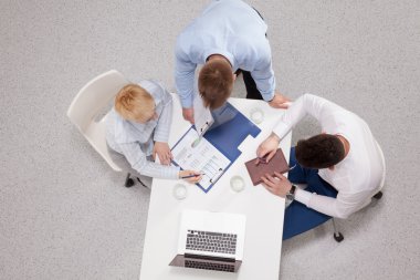 İş adamları iş toplantısında, ofiste oturup tartışıyorlar.