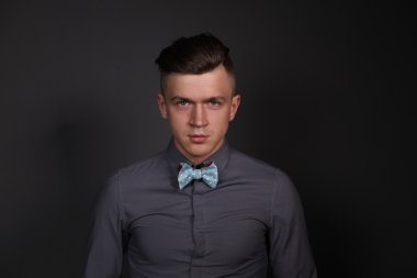 ayakta, gri arka plan üzerinde izole genç bir adam portresi