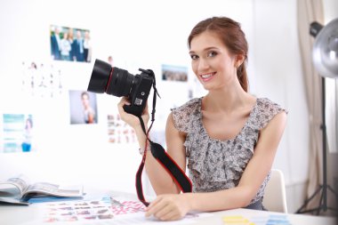 genç kadın fotoğrafçı masada oturan resimleri işleme