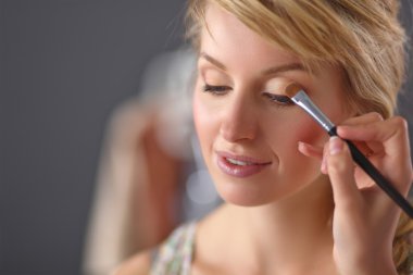 Kadından profesyonel makyaj yapan sanatçı.