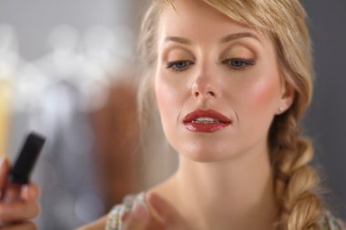 Kadından profesyonel makyaj yapan sanatçı.