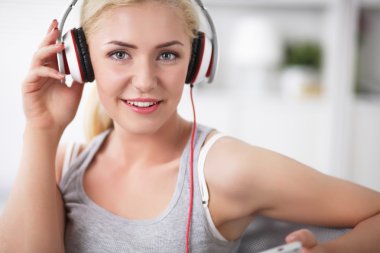 genç güzel kadın evde kanepede oturan ve müzik dinleme
