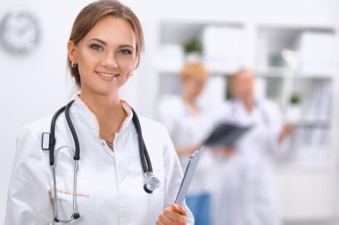 Kadın doktor hastanede dosyayla bekliyor.