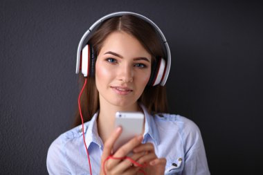 gri arka plan üzerinde izole kulaklık ile gülümseyen kız